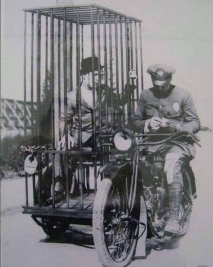 A Police Officer Transporting A Prisoner In A Holding Cell In 1921