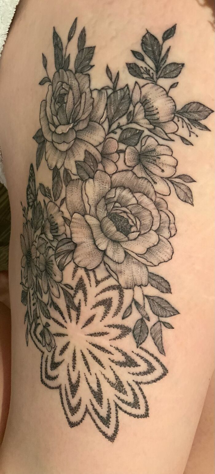 Floral tattoo with intricate rose and leaf design.