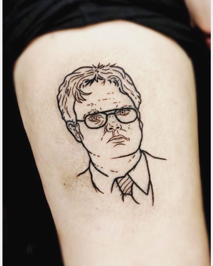 Tattoo of a character's face with glasses and a suit on light skin.