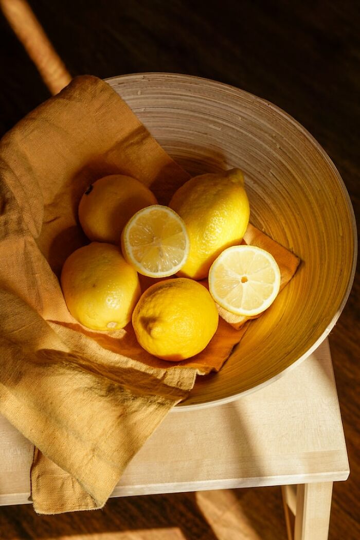Bowl of fresh lemons on a cloth, highlighting products many can no longer afford in current markets.