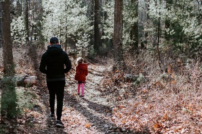 Adult and child walking in a forest path, illustrating themes related to bad parent perceptions and honest thoughts shared.