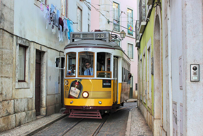 Yellow tram in narrow city street
