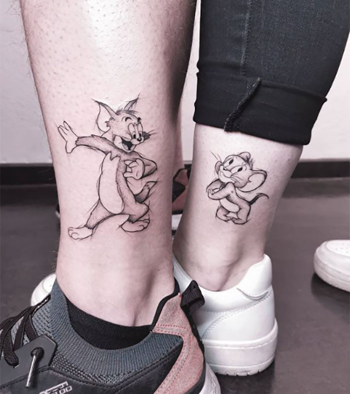 Sibling tattoos of cartoon cat and mouse on ankles, symbolizing brother and sister bond.