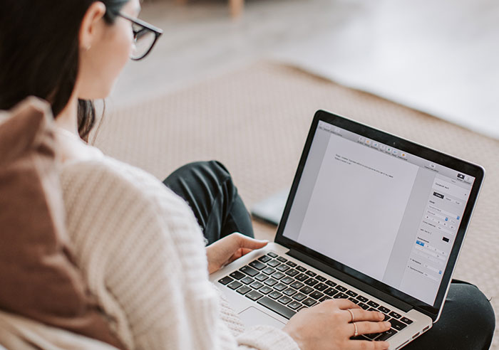 Woman working on laptop at home, exploring professions that may soon disappear, highlighting changes in job trends.