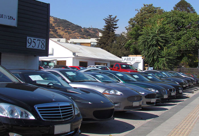 Row of luxury cars parked outside a dealership, illustrating professions that may soon disappear in car sales industry.