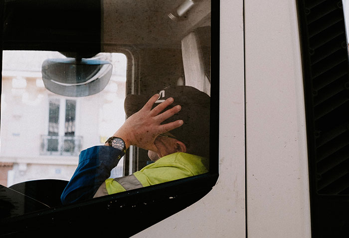 Truck driver resting inside vehicle, illustrating one of the professions that may soon disappear according to shared insights.