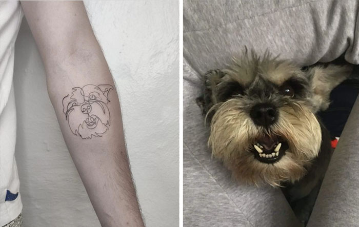 Line tattoo of a dog's face on a forearm, next to a real dog peeking through human legs.
