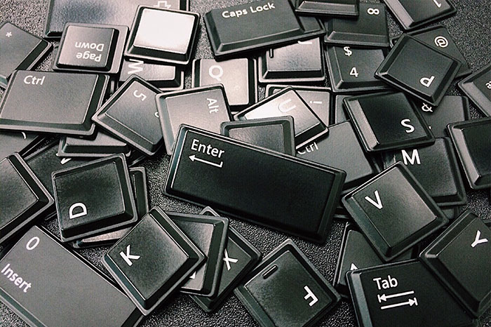 Scattered black keyboard keys including Enter, Caps Lock, and Tab representing texting games for phone conversations.