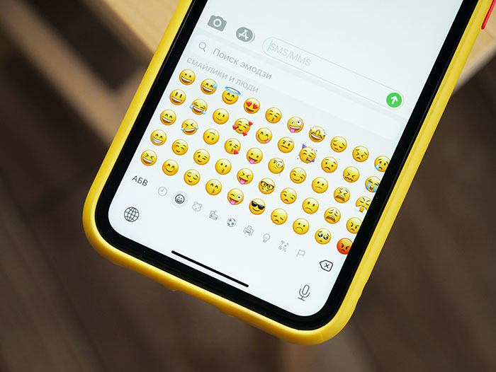 Smartphone screen with emoji keyboard open, illustrating texting games to juice up phone conversations.