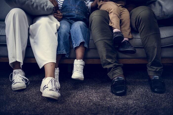 Family sitting on a couch, showing only their legs and feet, discussing common myths and misconceptions.