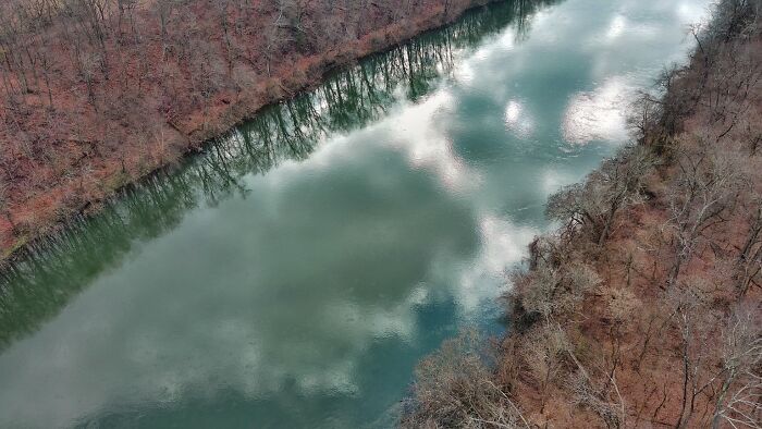 Reflection Of Clouds And Trees In The River