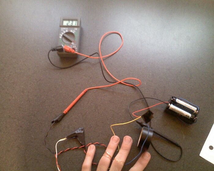 Multimeter and batteries connected with wires on a table, illustrating a common myth about electricity.