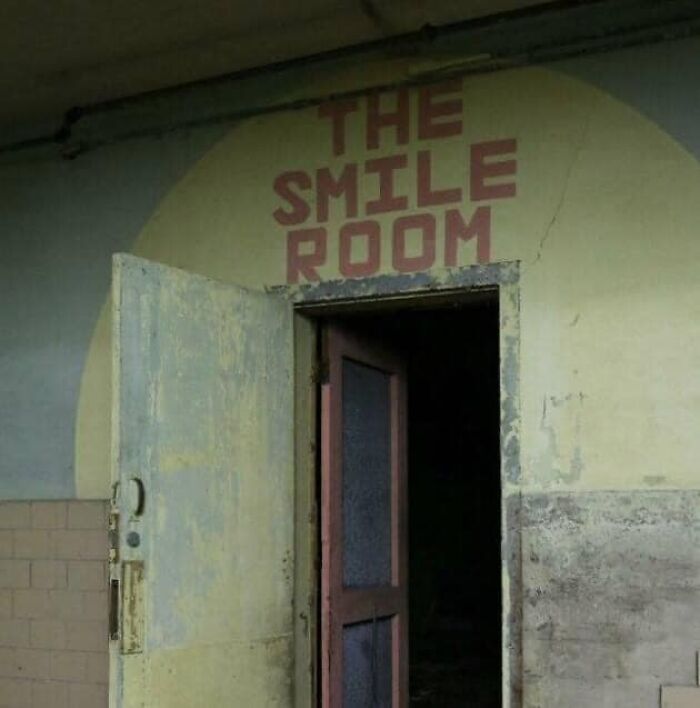 Worn door with a faded sign that reads The Smile Room, an example of hilariously absurd signs shared online.