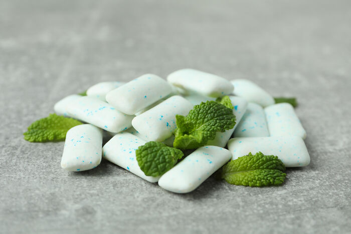 Mint-flavored chewing gum pieces with mint leaves, debunking common myths.