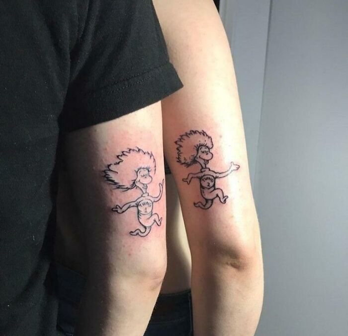 Brother and sister tattoos featuring matching cartoon figures on arms.