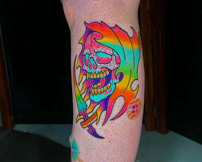 Colorful skull tattoo featuring psychedelic art elements on skin.