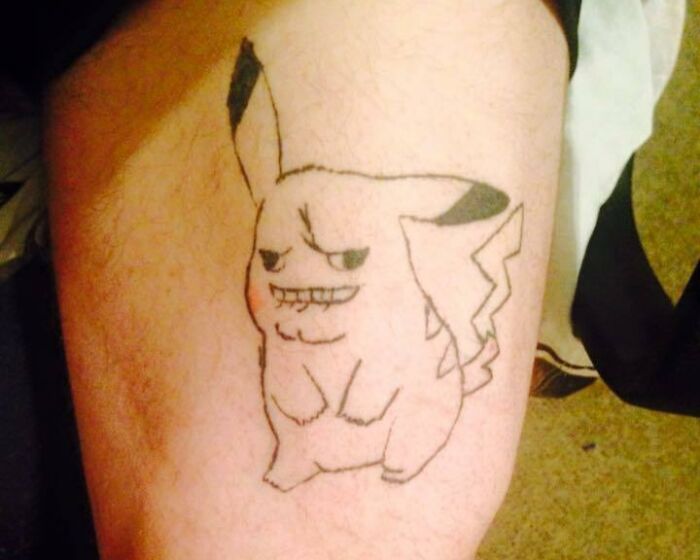 Funny Pikachu face tattoo on leg, showcasing quirky and humorous design.