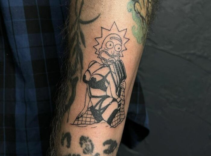 Funny tattoo of a cartoon character in a strange pose on an arm.