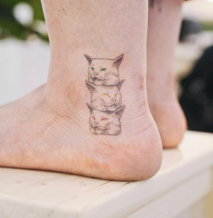 Funny tattoo of a three-headed cat on the ankle, blending whimsy with feline charm.