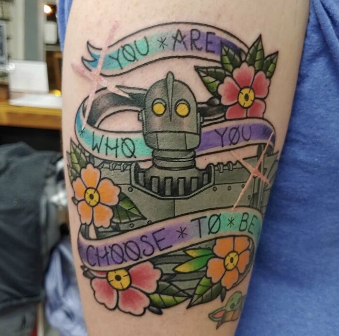 Robot and floral tattoo with text "You are who you choose to be," showcasing a creative word tattoo idea.