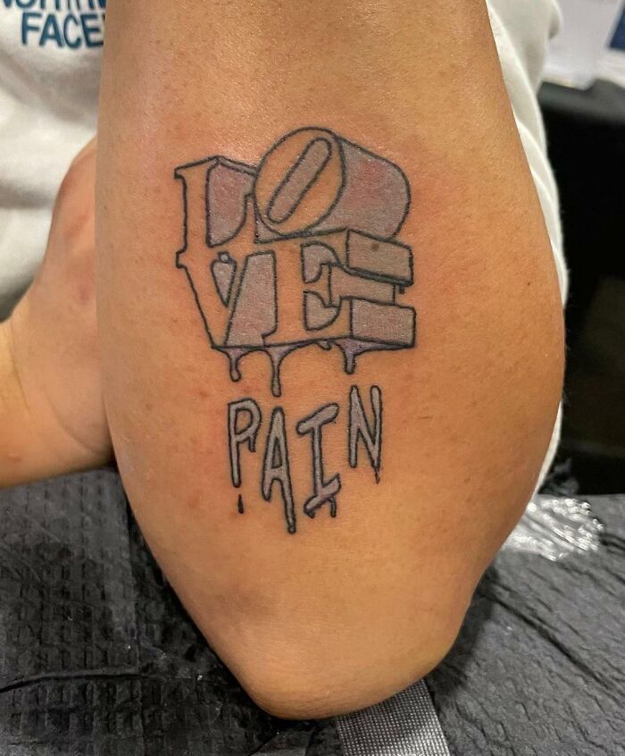 Tattoo showcasing the words "Love" and "Pain" in a bold, dripping style on an arm, a unique word tattoo idea.