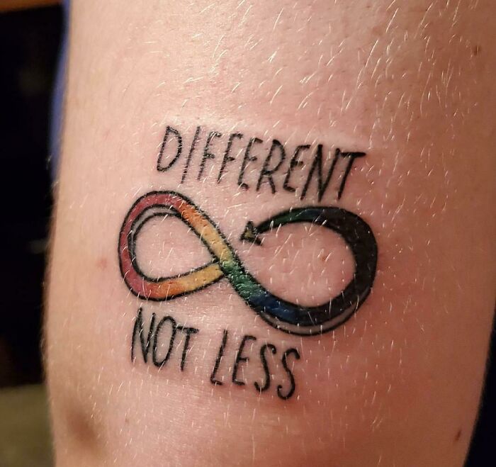 Colorful infinity word tattoo reading "Different Not Less" for creative inkspiration.