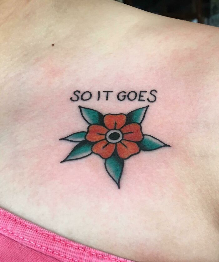 Word tattoo with 'So It Goes' above a colorful flower design on skin.