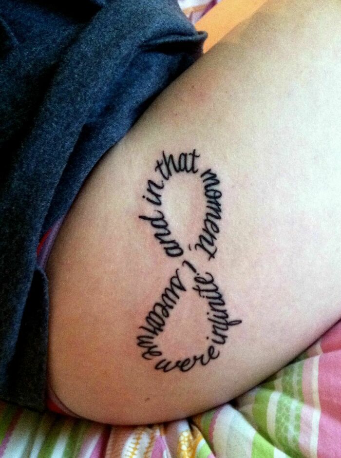 Infinity word tattoo on skin, featuring the phrase "and in that moment, we were infinite."