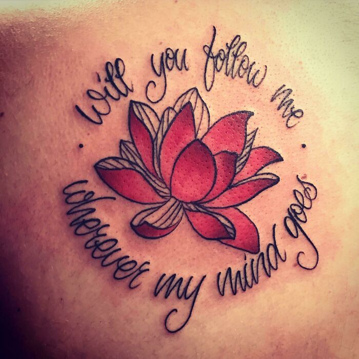 Word tattoo featuring a red lotus flower with the phrase "Will you follow me wherever my mind goes" in cursive.