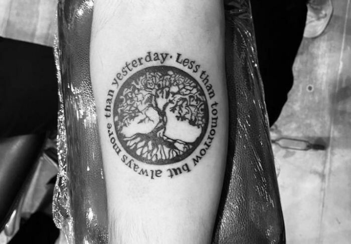 Word tattoo featuring a tree design and a meaningful quote about life and time.