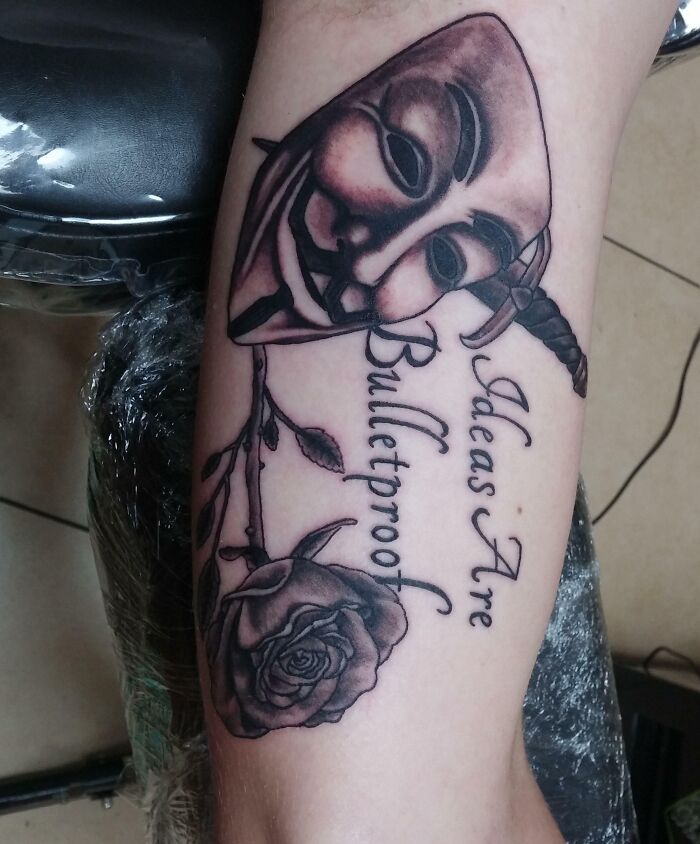 Tattoo design showcasing a mask and the phrase “Ideas Are Bulletproof” with a rose, highlighting word tattoo ideas.