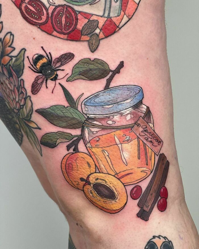 Nature tattoo featuring a bee, apricot jam jar, and leaves, celebrating the human-earth bond.