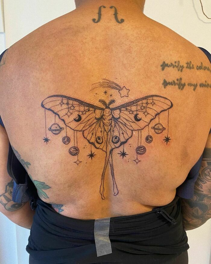 Nature tattoo featuring a detailed moth design with celestial elements on a person's back.