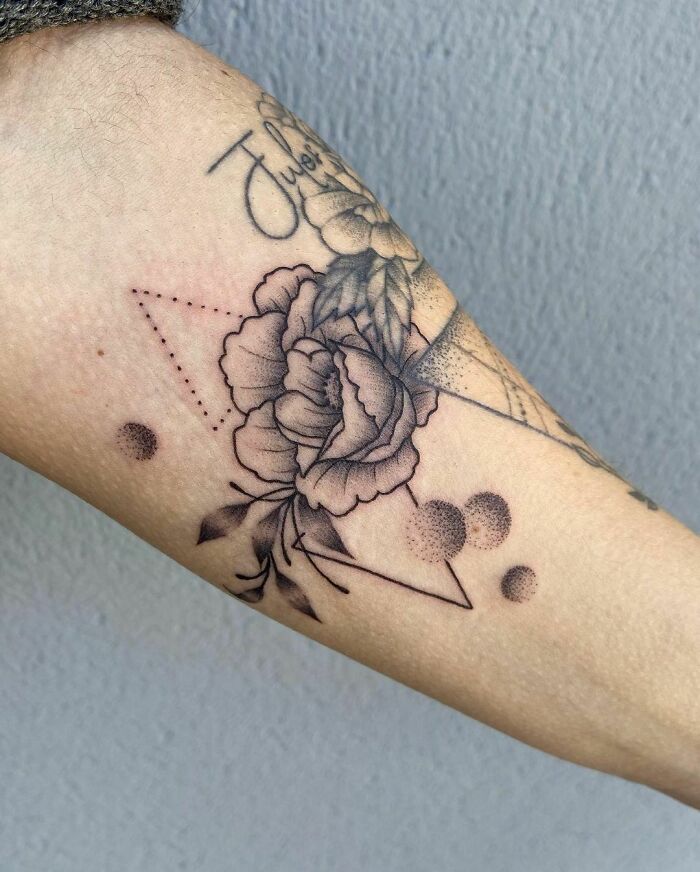Geometric nature tattoo with a rose design on forearm.