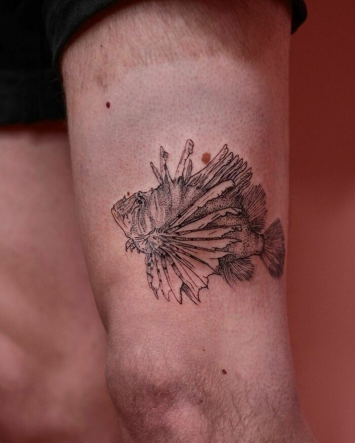 Detailed nature tattoo of a fish on a person's arm.