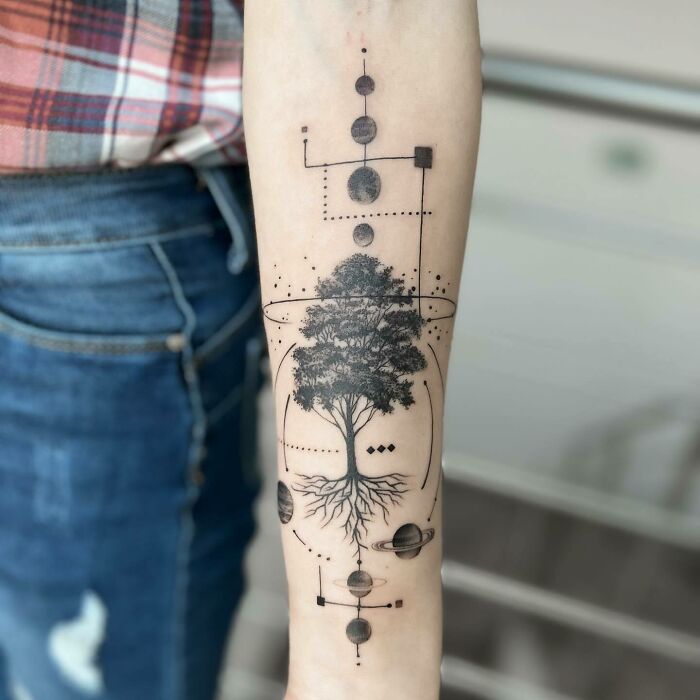Forearm with a tree tattoo incorporating geometric designs, symbolizing nature and a wild side.