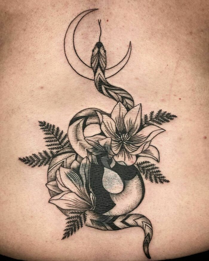 Nature tattoo featuring a snake, flowers, and crescent moon, symbolizing the wonders of Mother Earth.