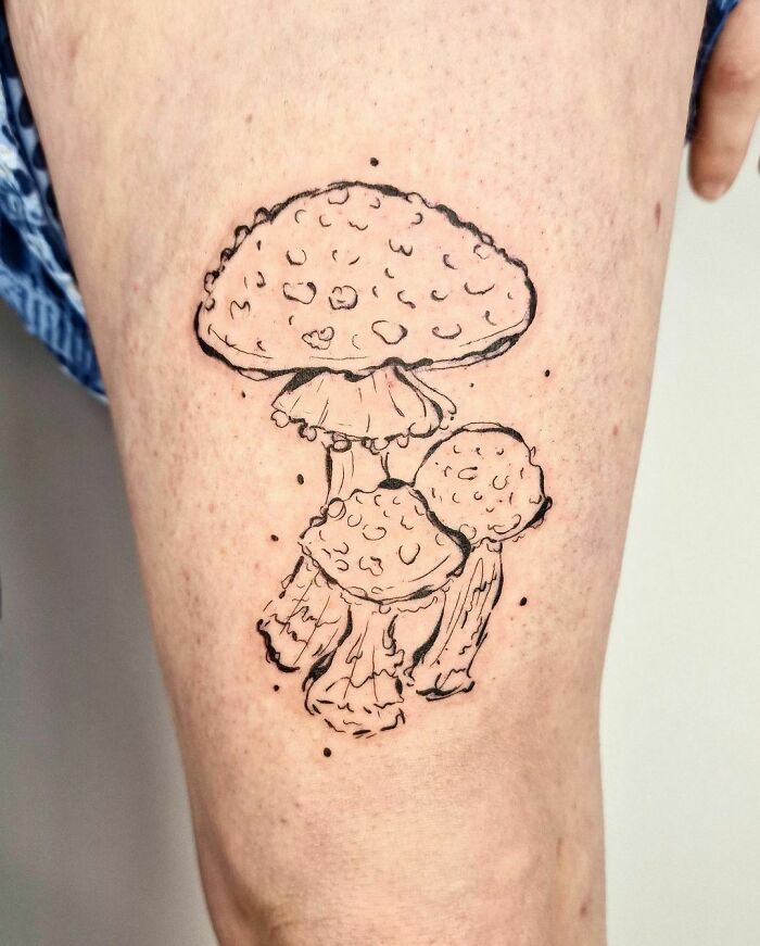 Mushroom nature tattoo on leg, celebrating human-earth bond.