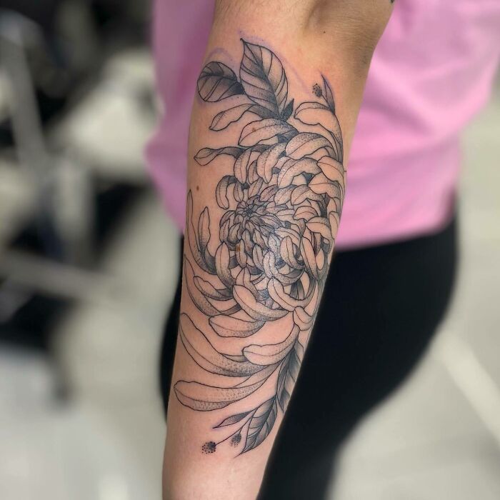 Floral nature tattoo on forearm featuring intricate petal and leaf design, celebrating the human-earth connection.