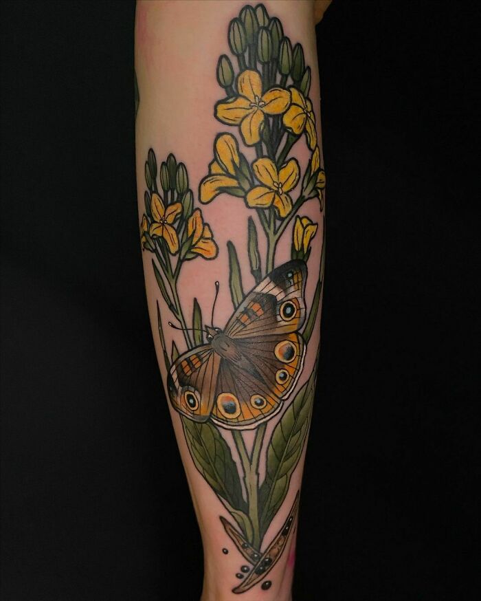Nature tattoo featuring a butterfly and yellow flowers on a forearm.