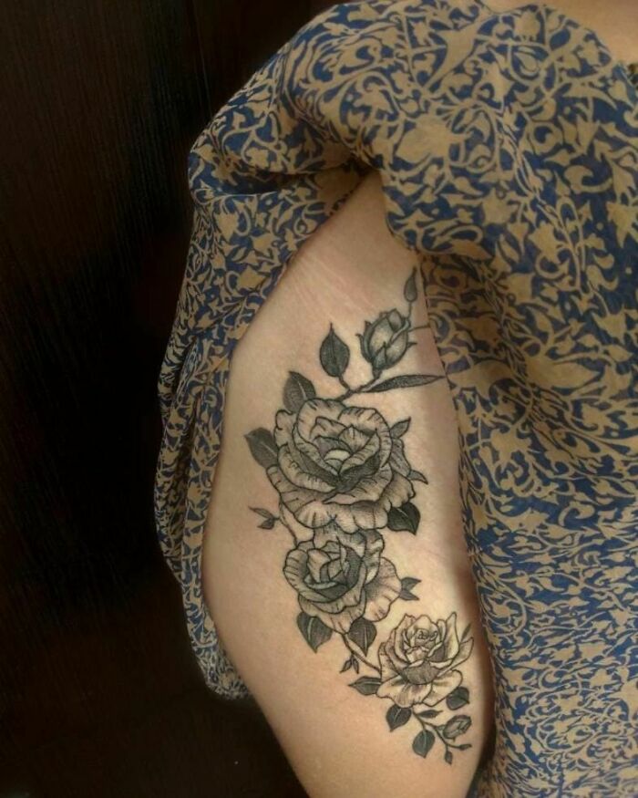 Nature tattoo of roses on an arm, showcasing intricate floral design.