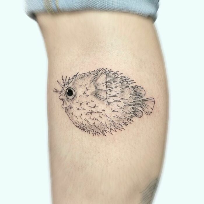 Pufferfish nature tattoo on a person's arm, showcasing aquatic life.