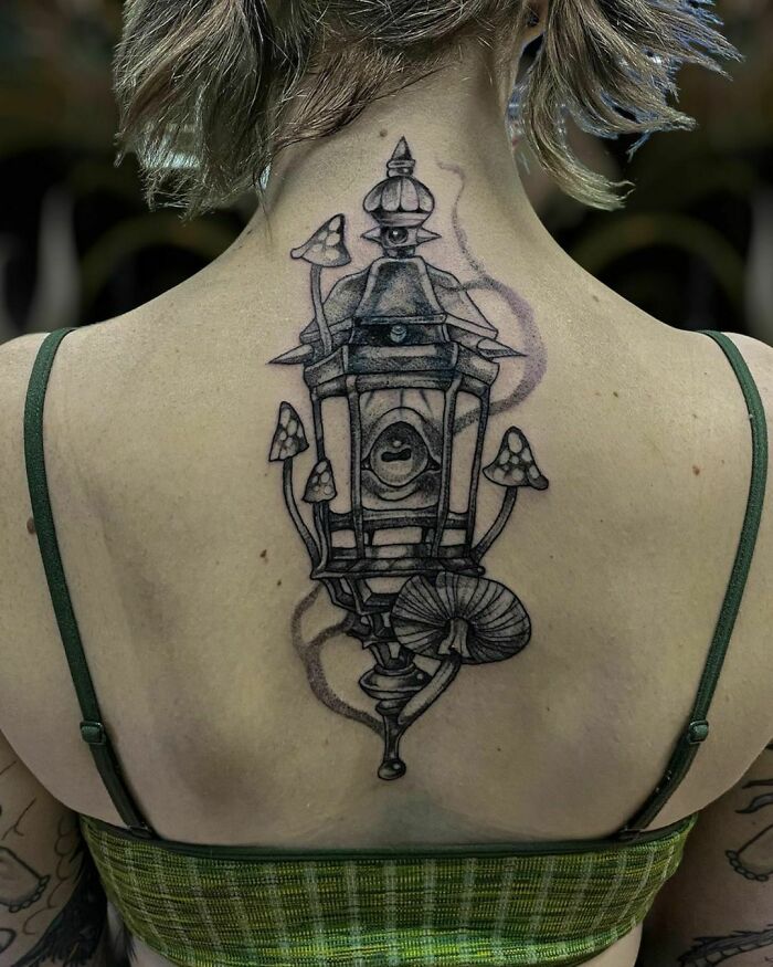 Lantern and mushrooms back tattoo, featuring nature-inspired design with intricate details.