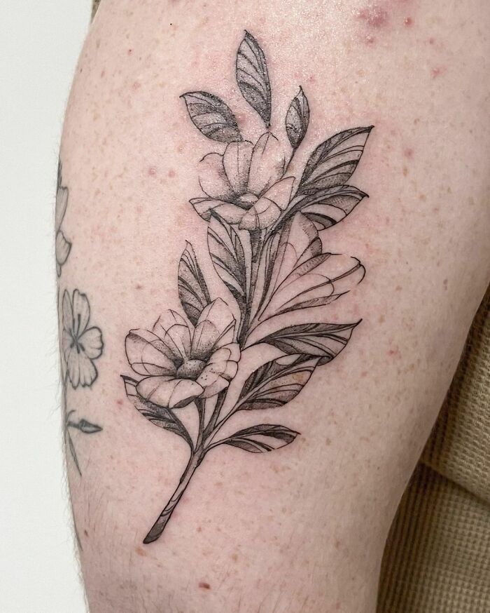 Floral nature tattoo on skin showcasing the human-earth bond with intricate leaf and flower design.