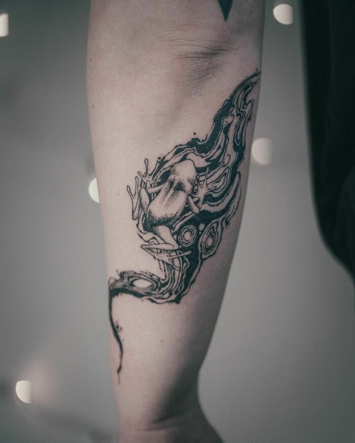 Nature tattoo of a frog with abstract designs on an arm, celebrating human-earth bond.