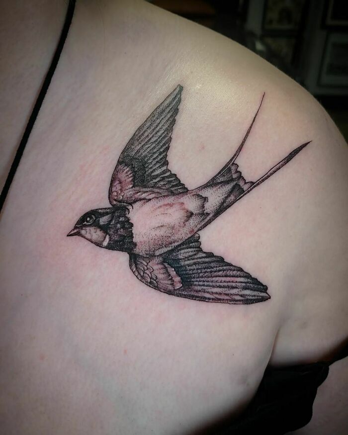Bird tattoo on shoulder, symbolizing human-earth bond in nature-inspired art.