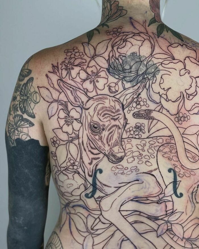 Back tattoo featuring a deer and floral motifs, celebrating nature tattoos.