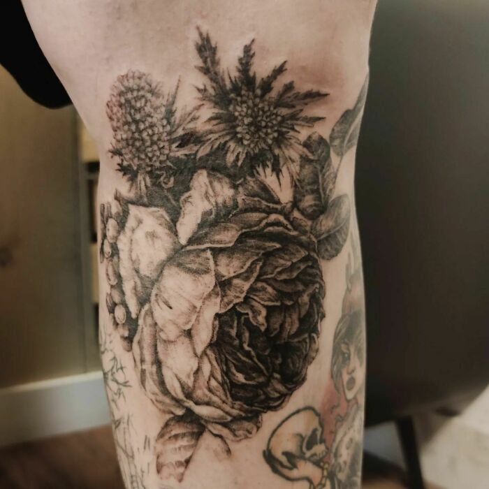 Nature tattoo depicting detailed floral design on the arm.