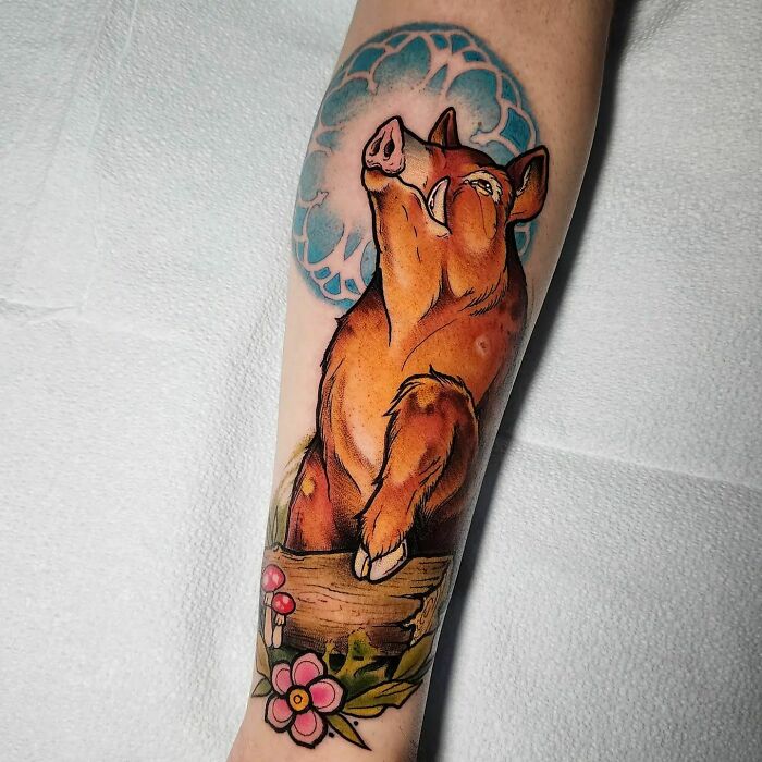 Nature tattoo of a boar with blue sky, flowers, and mushrooms on forearm, celebrating the wonders of Mother Earth.