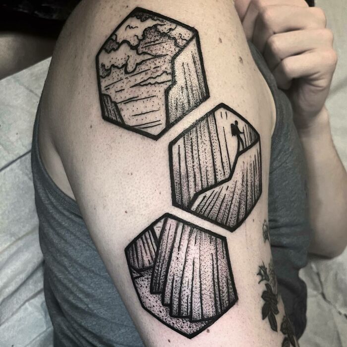 Geometric nature tattoos on upper arm featuring landscapes and natural elements.